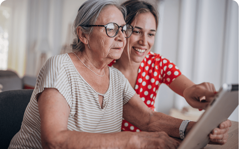 Elderly woman and young woman using tablet